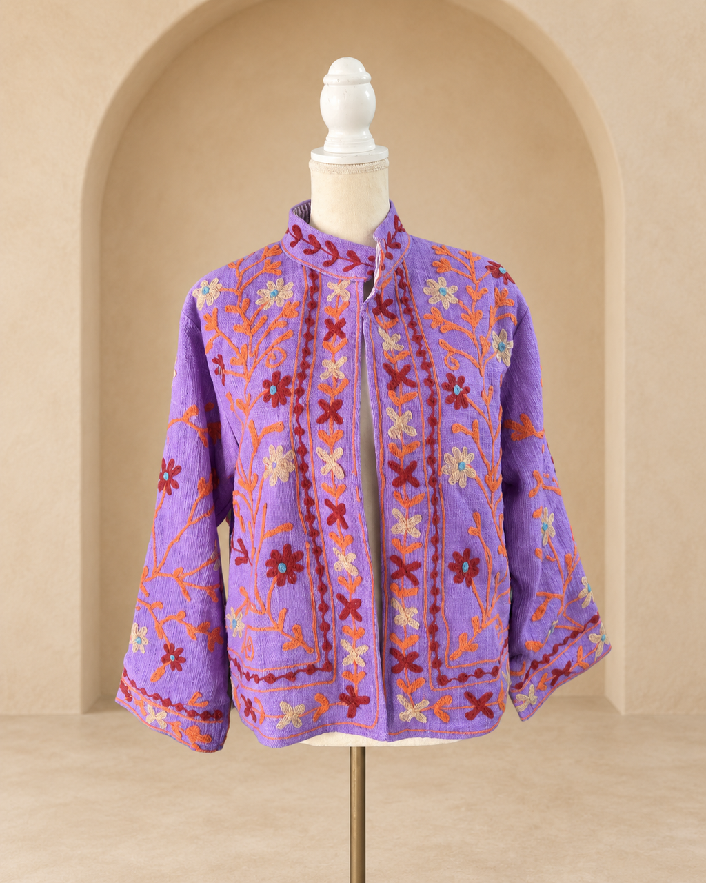 Vista frontal de blazer violeta de algodón tejido con bordado floral multicolor.