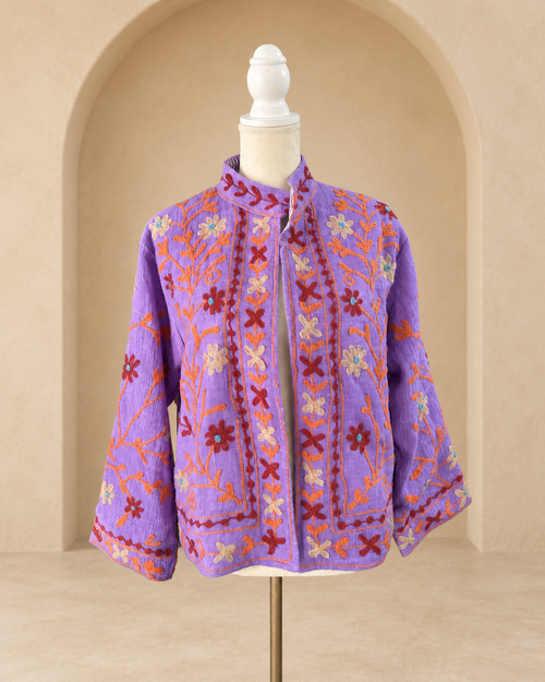 Vista frontal de blazer violeta de algodón tejido con bordado floral multicolor.