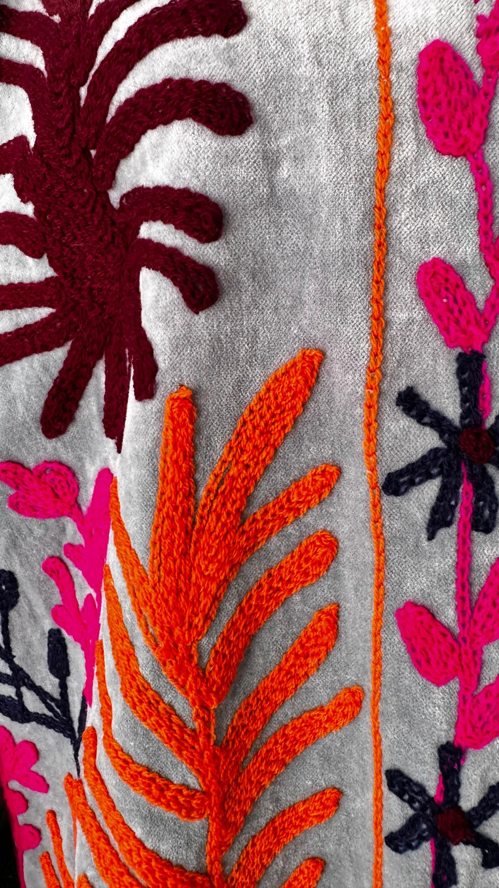 Detalle del bordado botánico en fucsia, naranja, vino y azul marino sobre velvet gris – Sundarata
